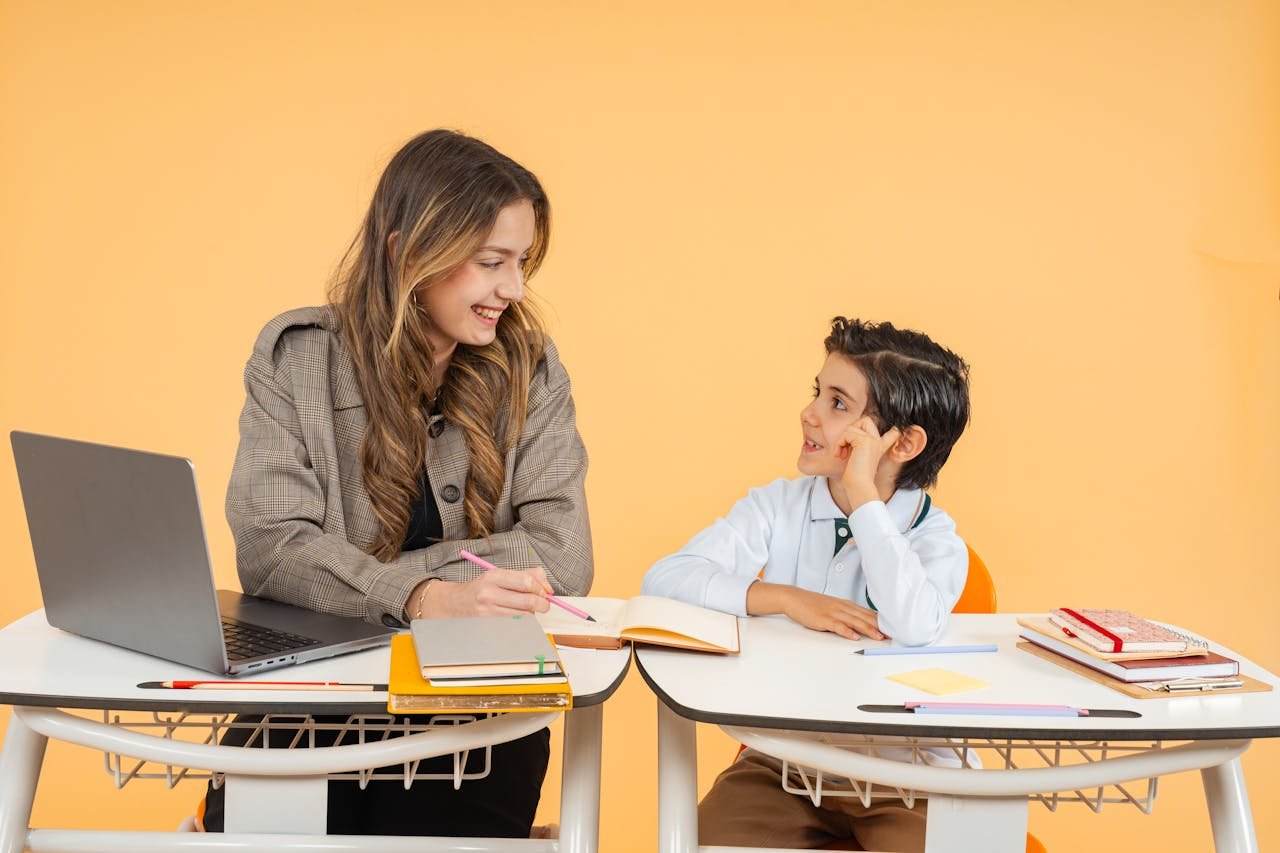 A teacher and student smile as they engage in a learning activity in a classroom.